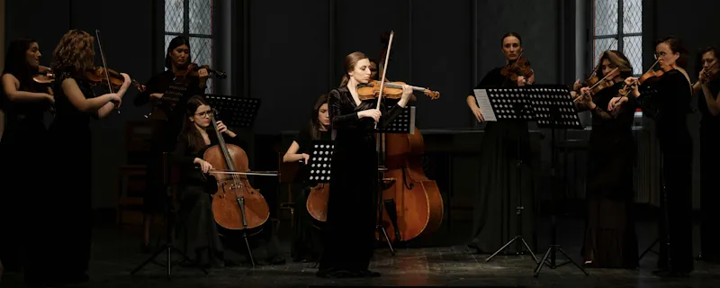 Klassiska musiker spelar stråkinstrument i konsertsal under framträdande