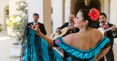 Kvinna dansar till liveband med traditionella latinamerikanska musiker, symbol för latinmusikens rytm och kulturella arv.