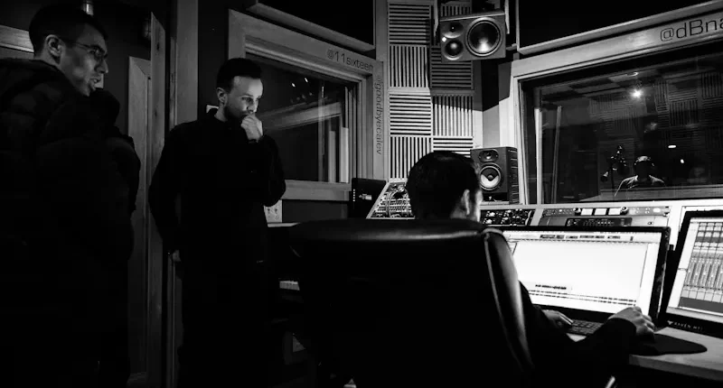 Låtskrivare och producent arbetar tillsammans i modern inspelningsstudio, symbol för den svenska låtskrivarmodellen och svensk popproduktion.