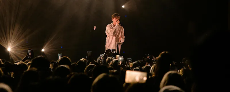 R&B-artist sjunger live på scen inför publik med mjuk scenbelysning