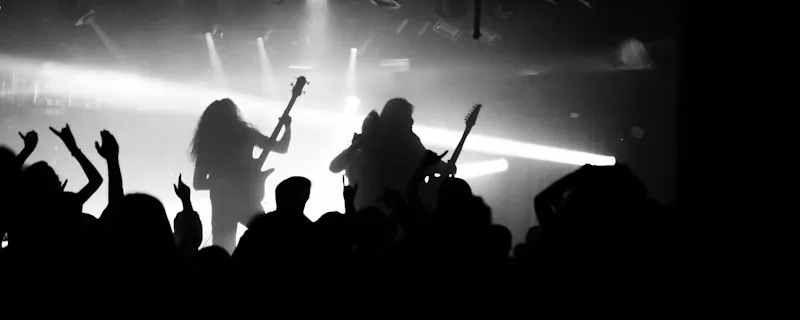 Rockartister uppträder live på scen med elgitarrer och kraftfulla scenljus