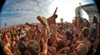 Publik crowdsurfar under en energisk festivalspelning på en utomhuskonsert i juli