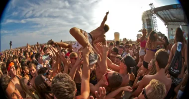 Publik crowdsurfar under en energisk festivalspelning på en utomhuskonsert i juli