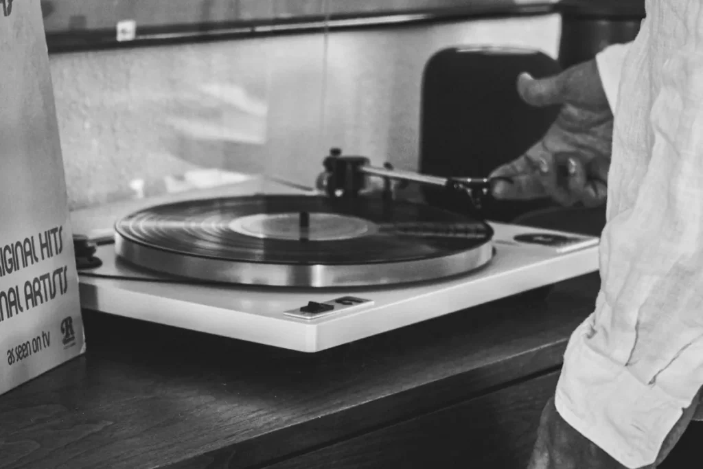 Vinylens återkomst är ett av de tydligaste bevisen på att musik inte bara handlar om ljud – utan om upplevelse, identitet och känsla. Trots att streaming dominerar totalt i antal lyssningar har vinyl vuxit stadigt i över ett decennium, och i flera stora marknader säljer vinyl nu fler album än cd-skivor. Det avgörande är att vinyl inte konkurrerar med streaming på samma sätt – den kompletterar den. Där streaming ger obegränsad tillgång, ger vinyl något helt annat: ägande, närvaro och en mer medveten relation till musiken. ### Därför exploderade vinylens popularitet igen Vinylens comeback började som en nisch men har blivit en global trend. Förklaringen ligger i flera samverkande faktorer. För det första har människor tröttnat på det helt digitala. Musik finns överallt, men upplevs ofta mer flyktigt. Vinyl erbjuder motsatsen – något konkret, något som tar plats och kräver engagemang. En annan avgörande faktor är att vinyl har repositionerats. Från att vara standardformat blev det ett premiumformat. I dag köper man inte vinyl för bekvämlighet, utan för upplevelse, kvalitet och samlarvärde. Det gör att priset kan vara högre utan att efterfrågan minskar. ### Den fysiska musikupplevelsen som streaming saknar Att spela en vinylskiva är en aktiv handling. Man tar fram skivan, placerar den på spelaren, sänker nålen och lyssnar. Den processen skapar ett fokus som saknas i dagens snabba musikflöden. Streaming gör det enkelt att hoppa mellan låtar, men vinyl uppmuntrar till att lyssna på hela album. Det förändrar hur musik upplevs. Många artister bygger sina album som helheter, med en tydlig dramaturgi, och det kommer verkligen till sin rätt på vinyl. ### Omslaget blev konst igen Vinylens stora format gör att omslaget får en helt annan betydelse. Det är inte bara en bild på en skärm, utan något man håller i händerna. Det gör att albumgrafik åter blivit en central del av musikupplevelsen. Artister och skivbolag har tagit fasta på detta. Många vinylutgåvor innehåller exklusiva detaljer som posters, färgade skivor, specialtryck och limiterade upplagor. Det gör att varje skiva kan kännas unik. ### Ljudet som engagerar mer än bara tekniskt Debatten om vinyl låter bättre än digitalt har pågått länge. Tekniskt sett kan digitalt ljud vara mer exakt, men många upplever vinyl som varmare och mer levande. Det handlar inte bara om ljudkvalitet i strikt mening, utan om hur ljudet upplevs. Vinyl har ofta mindre hård kompression och en annan dynamik, vilket kan ge en mjukare och mer naturlig känsla. Dessutom bidrar själva ritualen till att lyssningen upplevs som mer engagerande. ### Ritualen som gör lyssningen speciell En av vinylens största styrkor är ritualen. Att behöva vända skivan, att rengöra den, att aktivt välja vad man ska lyssna på – allt detta gör att musiken får mer tyngd. I en värld där allt går snabbt och är tillgängligt direkt blir det långsamma en kvalitet i sig. Vinyl erbjuder en paus från det ständiga flödet. ### Unga driver trenden lika mycket som äldre Det är inte bara nostalgiker som köper vinyl. En stor del av köparna är unga människor som aldrig upplevt vinylens första storhetstid. För dem är vinyl något nytt och annorlunda. Det representerar autenticitet i en digital värld. Att äga en skiva kan kännas mer personligt än att ha en spellista som alla andra också kan skapa. ### Samlarvärdet har blivit en nyckelfaktor Vinyl fungerar i dag lika mycket som samlarobjekt som musikformat. Limiterade upplagor, färgade pressningar och exklusiva versioner gör att skivor kan få ett helt annat värde än bara musiken de innehåller. Det har skapat en marknad där fans ibland köper flera versioner av samma album. Det handlar inte bara om att lyssna – utan om att samla. ### Skivbutiker och kultur runt vinyl Vinylens återkomst har också gett nytt liv åt skivbutiker. Att bläddra bland skivor, hitta oväntade album och prata med personal eller andra kunder är en upplevelse i sig. Evenemang som skivsläpp och temadagar har gjort vinyl till en social aktivitet. Det är något som streaming inte kan ersätta. ### Record Store Day och hype-effekten Ett tydligt exempel på vinylens kulturella kraft är Record Store Day. Under dessa dagar släpps exklusiva vinylutgåvor som lockar köer till skivbutiker över hela världen. Det visar att fysisk musik fortfarande kan skapa hype och engagemang på ett sätt som digitala releaser sällan gör. ### Begagnatmarknaden och jakten på fynd En stor del av vinylens charm ligger i begagnatmarknaden. Där kan man hitta allt från billiga klassiker till sällsynta samlarobjekt. Det gör att vinyl också blir en form av upptäcktsresa. Varje skiva har en historia, och ibland även spår av tidigare ägare. ### Teknikens roll i comebacken Vinylens återkomst hade inte varit möjlig utan att det blivit lättare att köpa skivspelare igen. I dag finns allt från enkla modeller till avancerade hifi-system. Det har gjort att fler kan komma igång utan stora investeringar. Samtidigt finns det en tydlig uppgraderingskultur där många förbättrar sin utrustning över tid. ### Vinyl som livsstil och identitet Att samla på vinyl handlar ofta om mer än musik. Det är ett sätt att uttrycka smak och identitet. Skivsamlingen blir en spegling av vem man är. Det gör att vinyl också fått en plats i inredning och sociala medier. Skivor visas upp, fotograferas och blir en del av hur människor presenterar sig själva. ### Varför vinyl fortsätter växa Vinylens framgång bygger på att den fyller en funktion som inget annat format riktigt gör. Den kombinerar musik, konst, samlande och upplevelse i ett och samma objekt. Streaming kommer fortsätta dominera när det gäller tillgänglighet. Men vinyl kommer fortsätta växa så länge människor vill ha något mer än bara tillgång – något de kan hålla i, uppleva och göra till sitt eget.